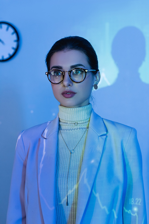 businesswoman in glasses and suit looking away in office