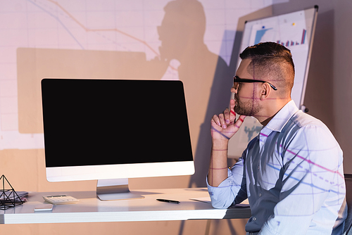 businessman in glasses looking at computer monitor with blank screen