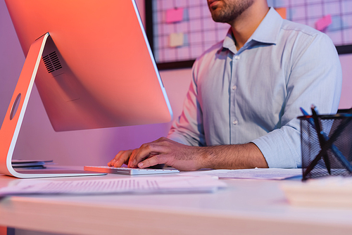 cropped view of businessman typing on computer keyboard near monitor