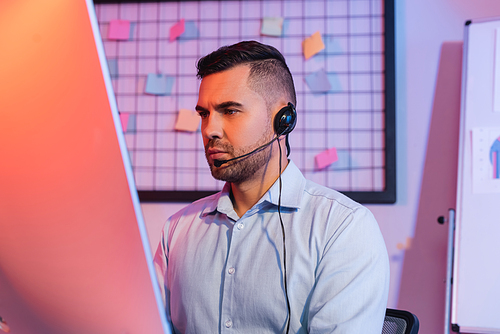 operator in headset looking at computer monitor