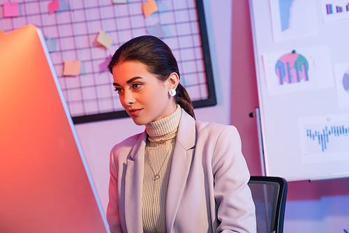 attractive businesswoman looking at computer monitor in office