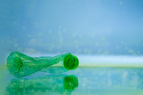 crumpled plastic bottle in water, ecology concept