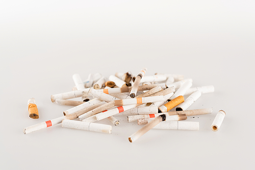 pile of cigarette ends on white surface, ecology concept