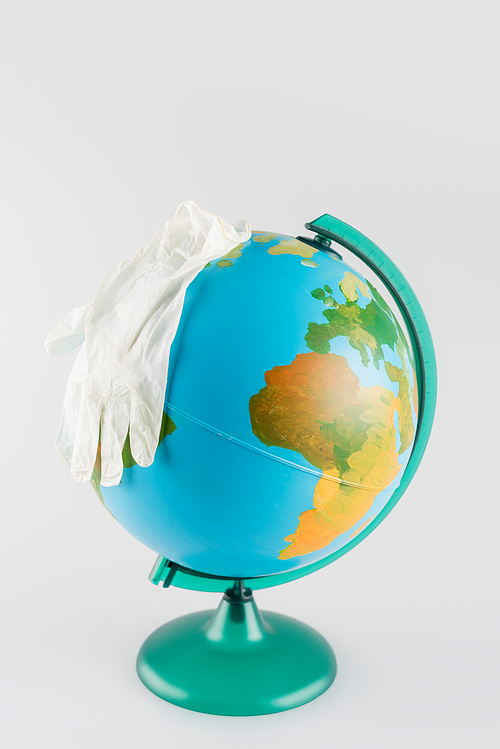 latex gloves on globe isolated on grey, ecology concept