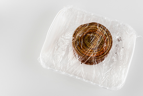 top view of rusty tin on plastic plate packed in cellophane, ecology concept