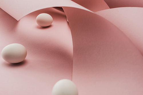 selective focus of chicken eggs in spiral paper pink swirls