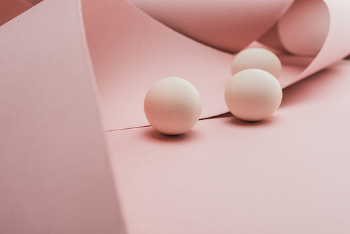 selective focus of chicken eggs in spiral paper pink swirls