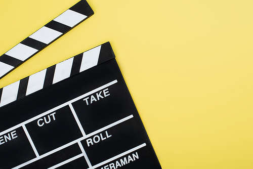 top view of clapperboard on yellow background with copy space, cinema concept