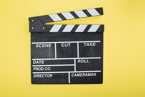 top view of clapperboard on yellow, cinema concept