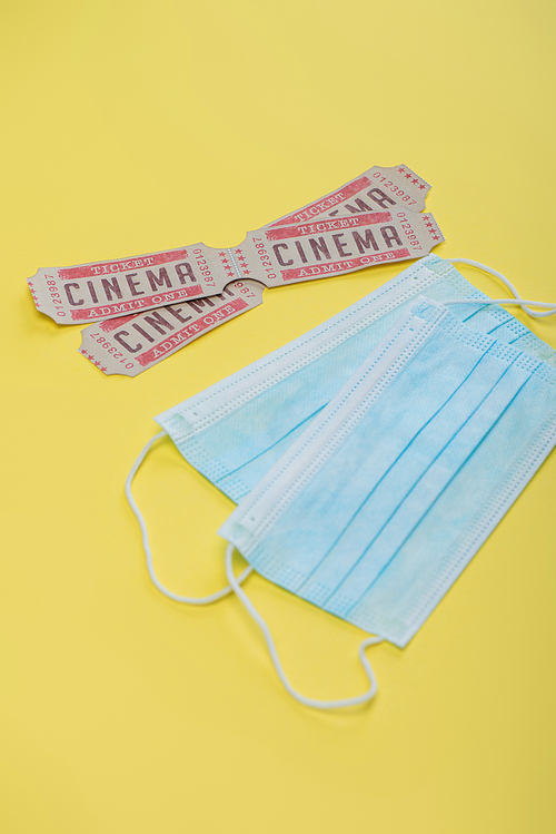cinema tickets near medical masks on yellow, cinema concept