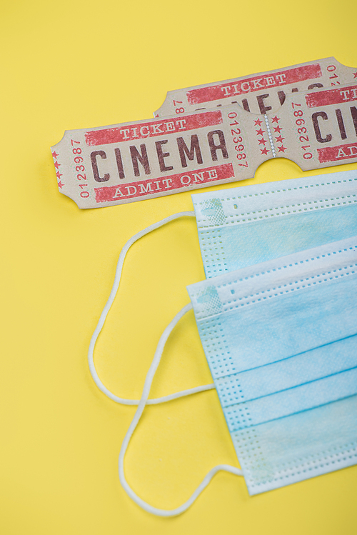 top view of cinema tickets near medical masks on yellow
