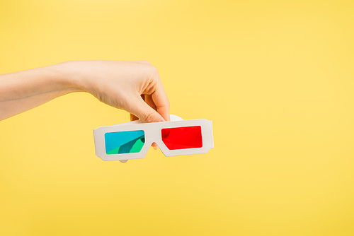 partial view of female hand with 3d glasses isolated on yellow, cinema concept