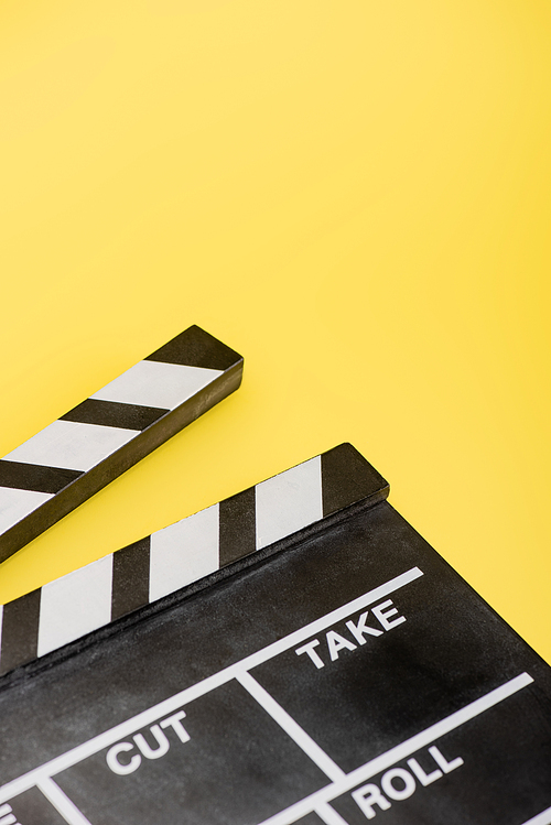 close up view of clapperboard on yellow, cinema concept