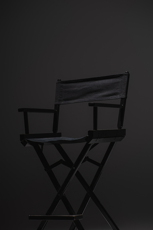 black, modern director chair on dark grey background, cinema concept