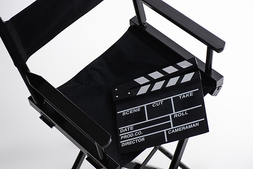 high angle view of clapperboard on director chair on white, cinema concept