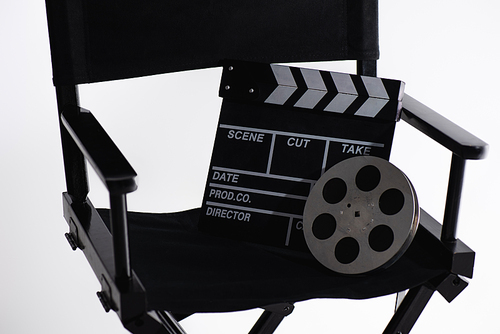 filmmaker chair, clapperboard and film bobbin on white, cinema concept