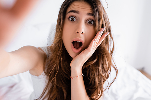 Excited woman in pajama  in bedroom on blurred background