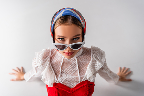 young trendy woman in headscarf and sunglasses  on white