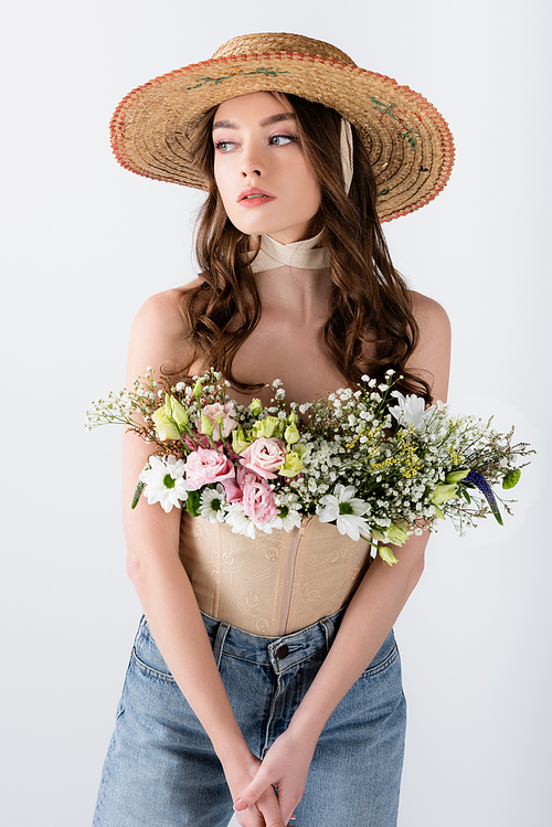 Model in sun hat with flowers in blouse isolated on grey