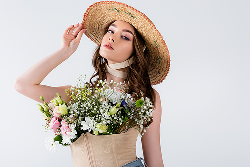 Fashionable model posing with flowers in blouse isolated on grey