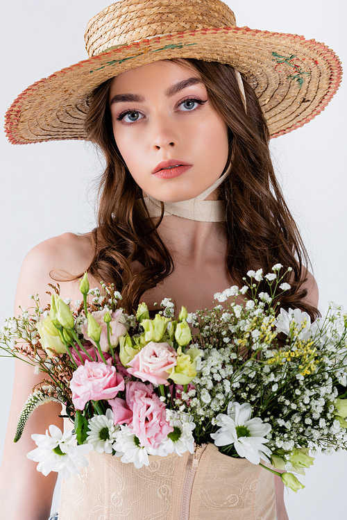 Brunette woman in straw hat with flowers  isolated on grey