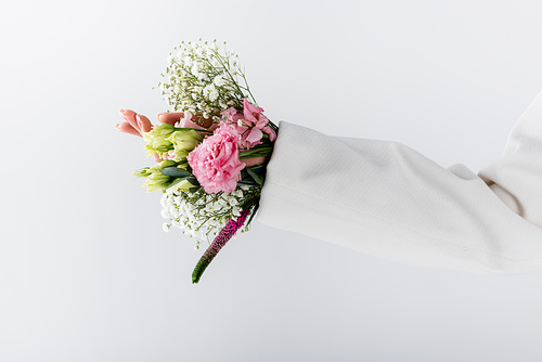 Cropped view of woman with different flowers in sleeve of jacket isolated on grey