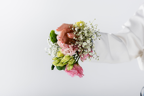 Cropped view of woman with different flowers in sleeve of blazer isolated on grey