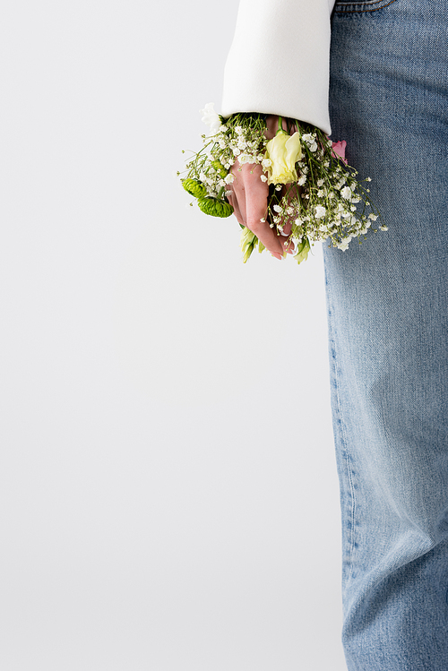 Cropped view of woman with small flowers in sleeve of jacket isolated on grey