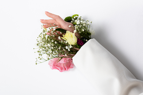 Cropped view of female hand with different flowers in sleeve on grey background