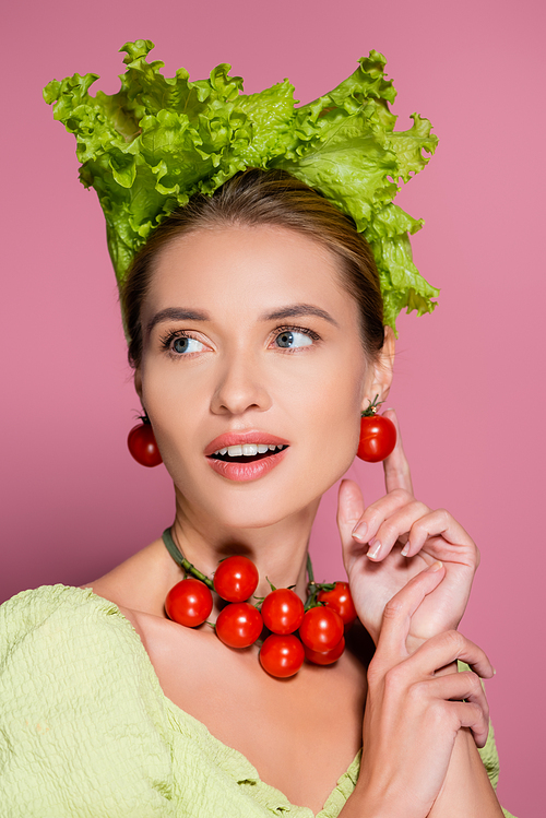 pretty woman in lettuce hat, and earrings made of cherry tomatoes on pink