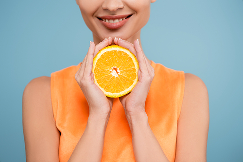 cropped view of smiling woman with half of ripe orange isolated on blue