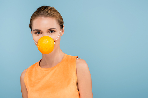 young woman wearing safety mask made of orange half isolated on blue