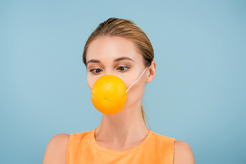 young woman in safety mask made of orange half isolated on blue