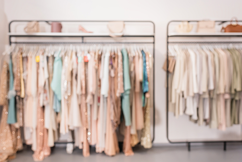 Blurred background of clothes on hanger racks in showroom