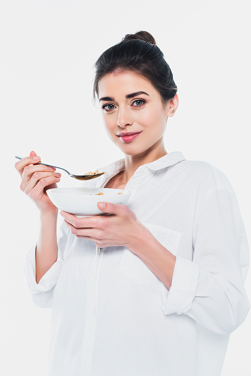 Pretty woman holding bowl with cereals and spoon isolated on white
