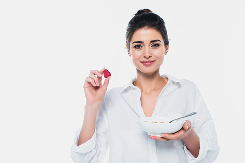 Brunette woman holding strawberry and cereals isolated on white
