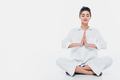 Brunette woman in white clothes practicing yoga on white background