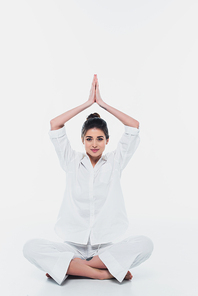 Young woman in clothes meditating on white background