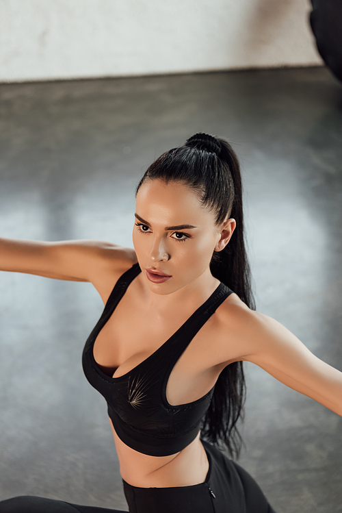 High angle view of sportswoman with outstretched hands in gym