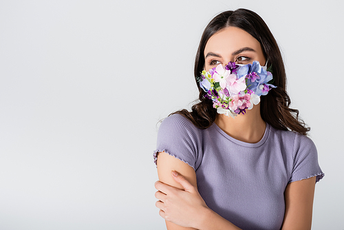 young woman in medical mask with flowers isolated on white