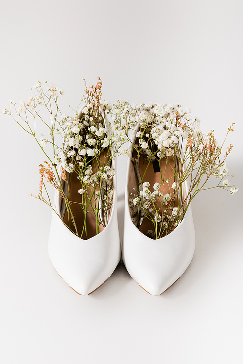 heeled shoes with blooming gypsophila flowers on white