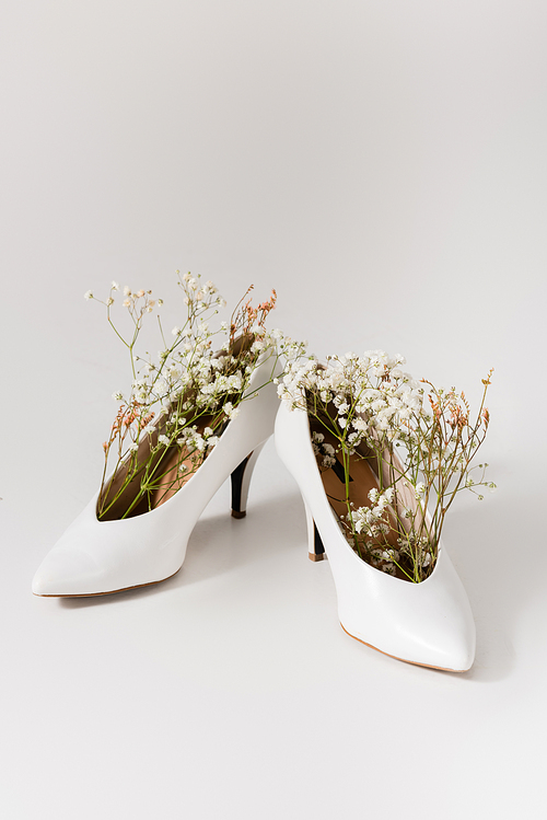 heeled shoes with gypsophila flowers on white