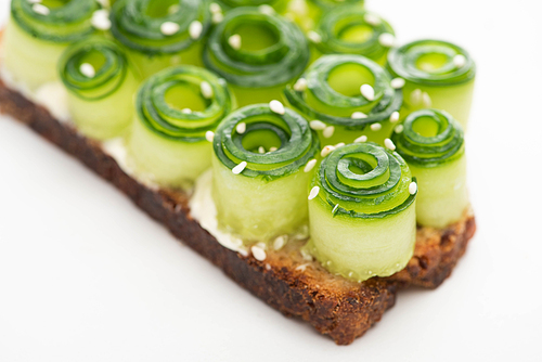 close up view of fresh cucumber toast with sesame on white background