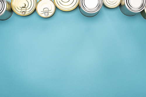 top view of cans on blue background with copy space, food donation concept