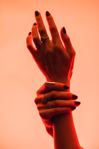 partial view of female hands with rings on fingers on pink