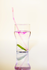 glass with lime in alcohol drink with purple syrup on white