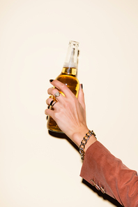 cropped view of woman holding bottle with beer on white