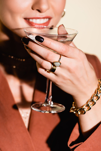 cropped view of happy woman holding glass of alcohol drink on white