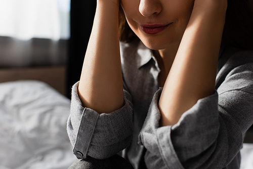 cropped view of upset woman touching face with hands