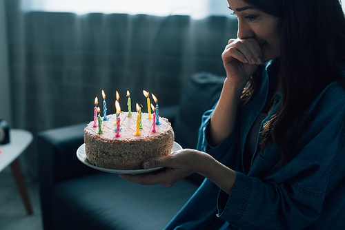 frustrated woman looking at birthday cake with candles